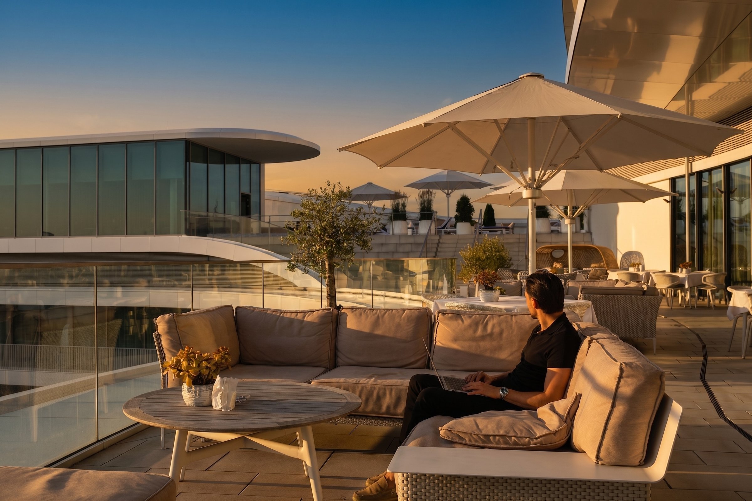 Rooftop terrace, guest working at sunset