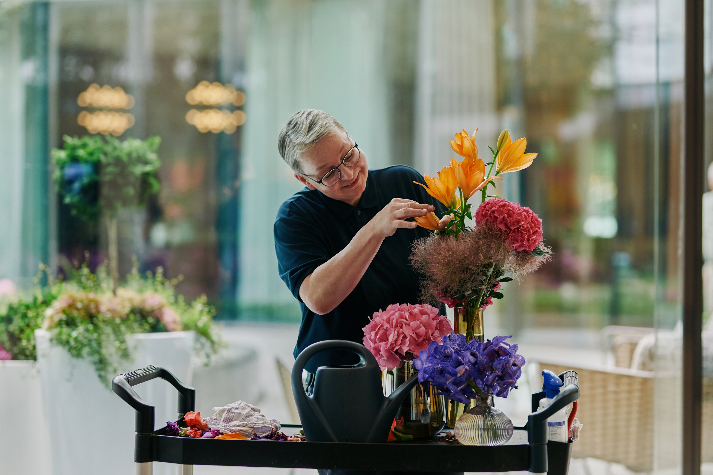 Florist arranging lilies and hydrangeas, close-up
