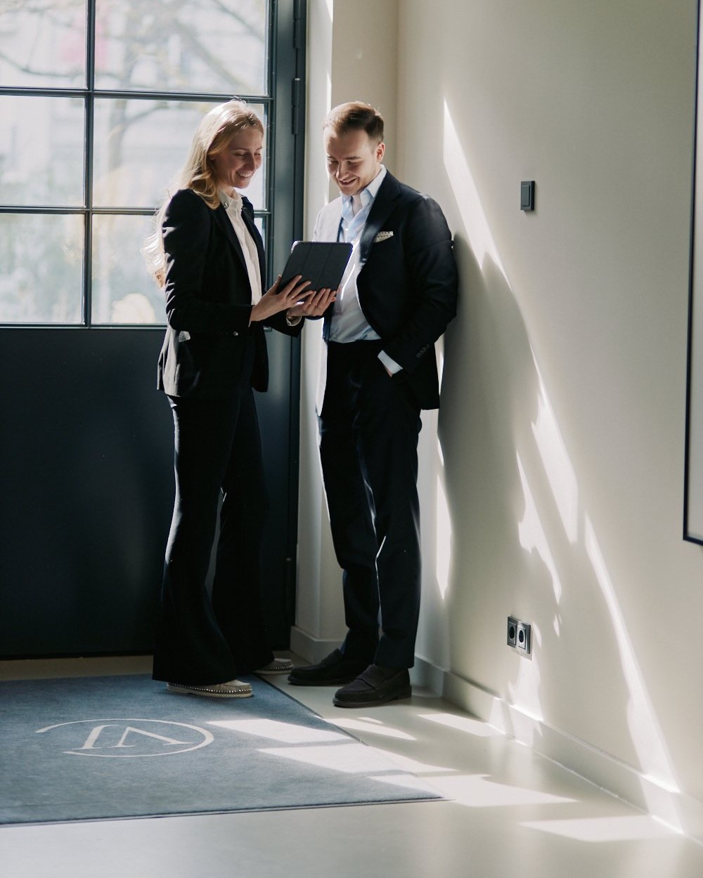 Colleagues in office hallway with tablet