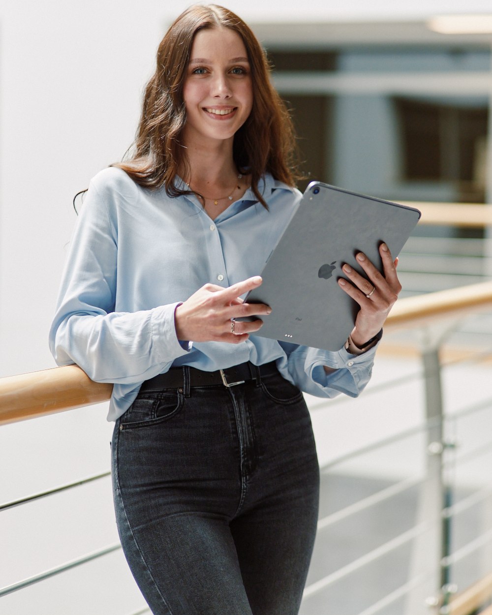 Office portrait, holding a tablet at a railing