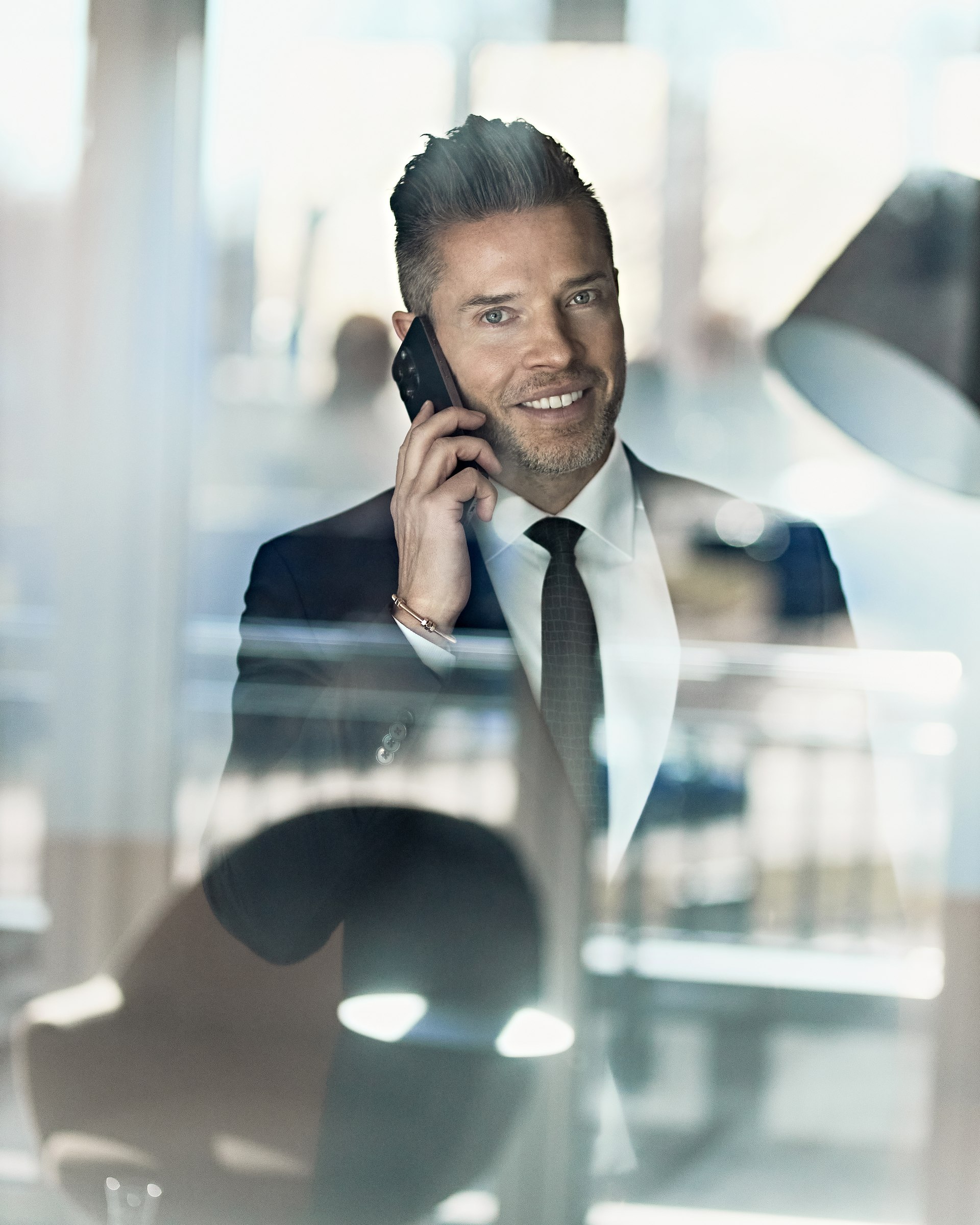 Executive portrait, on the phone behind glass