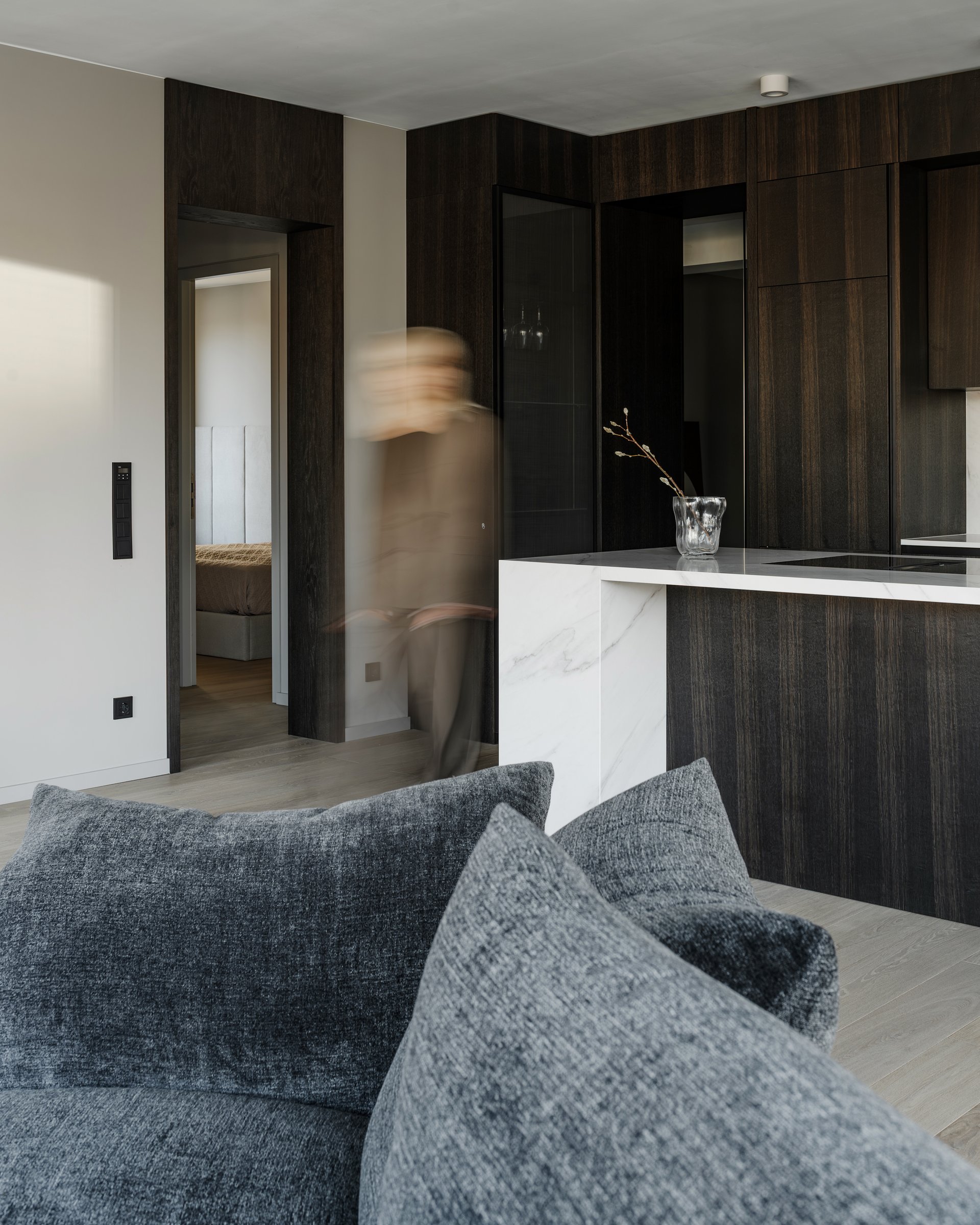 Dark apartment, kitchen and living room, figure in motion