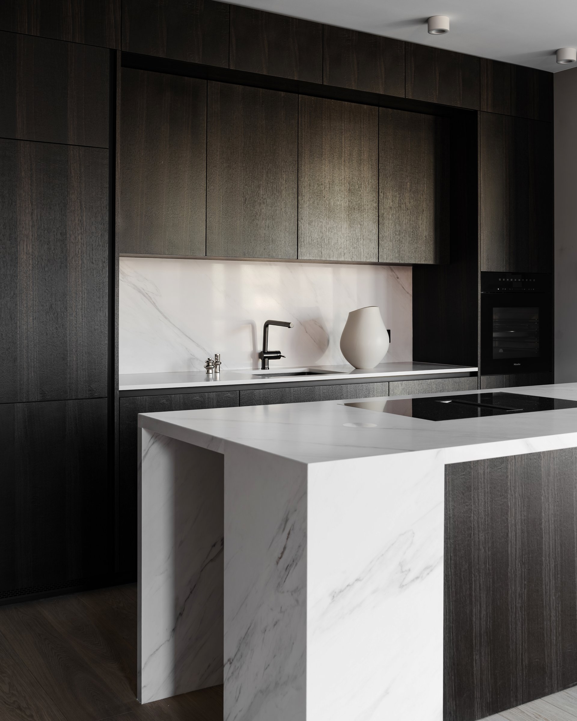Dark apartment, kitchen counter and marble backsplash