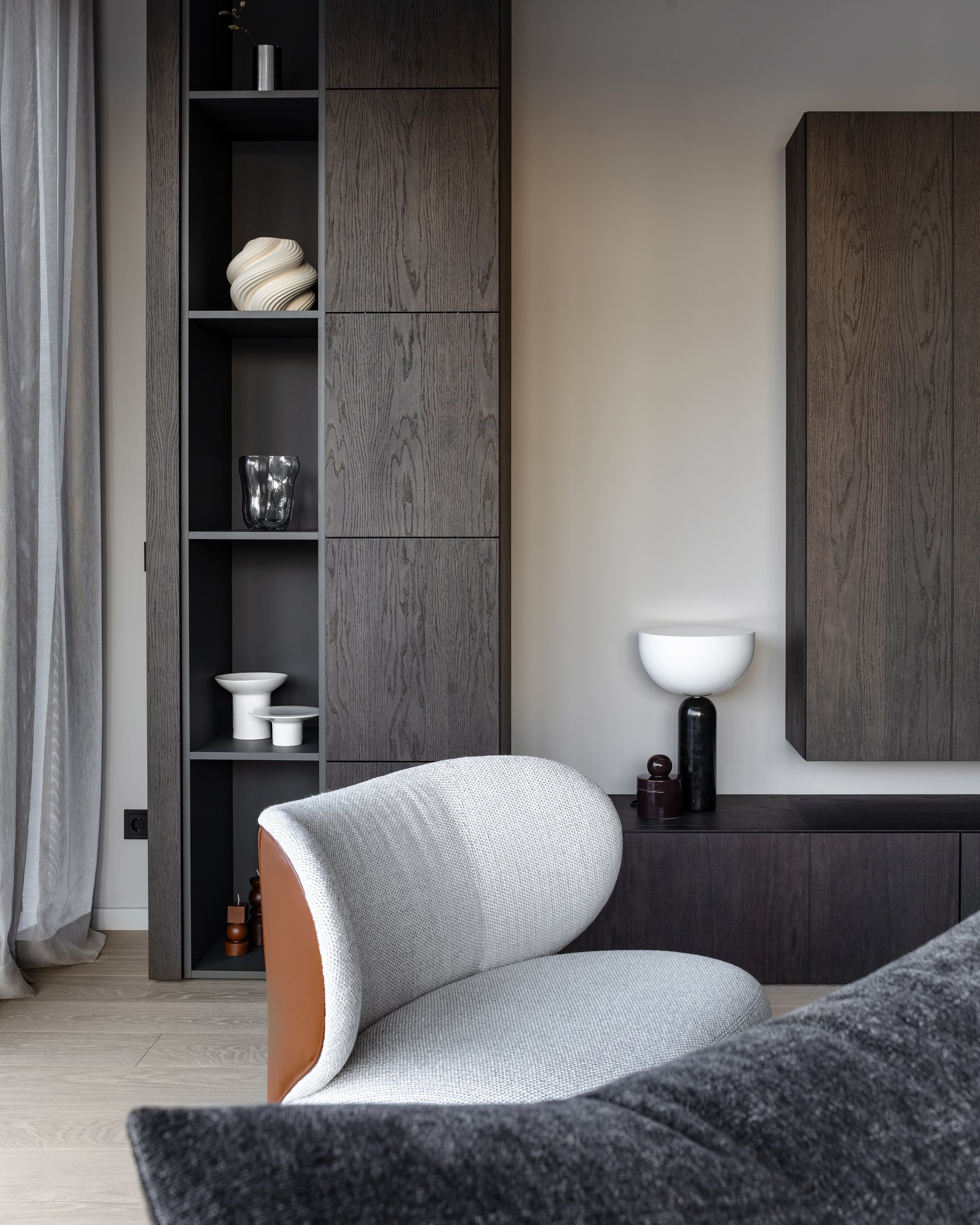 Dark apartment, shelving detail and lounge chair