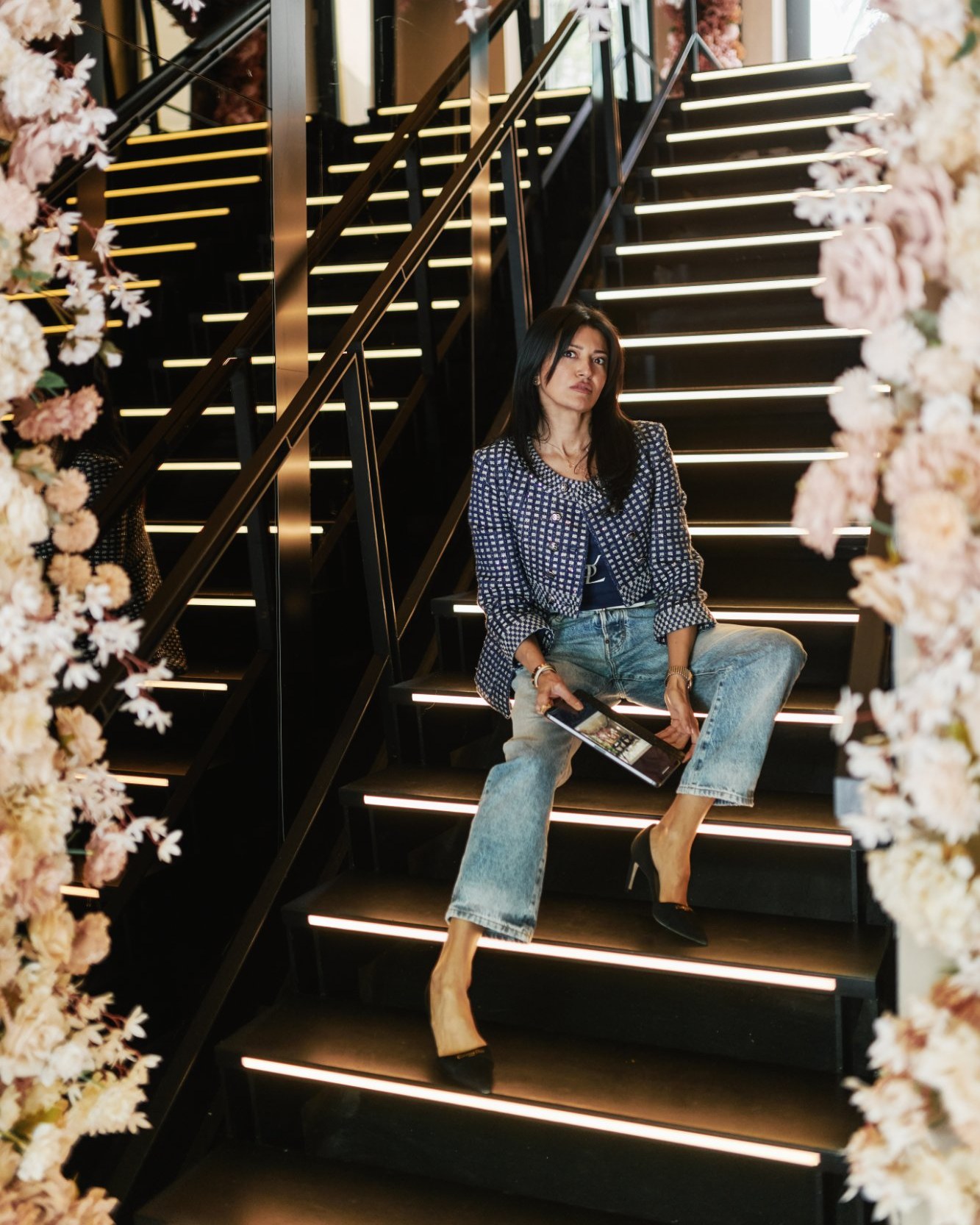 Signature portrait, seated on staircase, floral installation