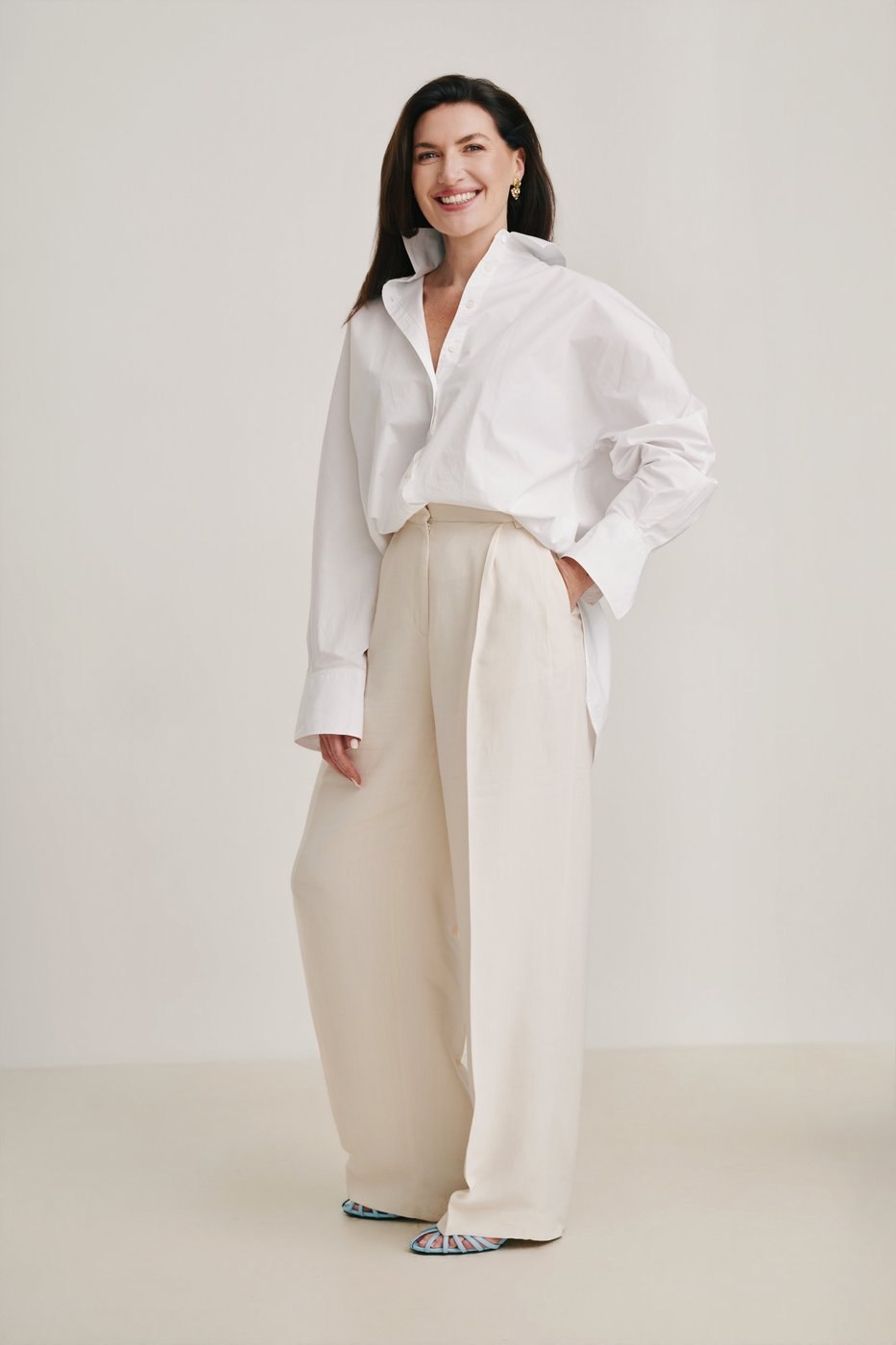Studio portrait, full length, white shirt and cream trousers