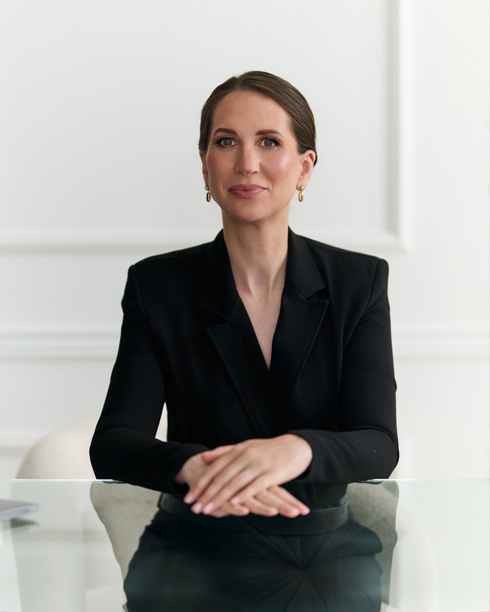 Studio portrait, seated at glass desk