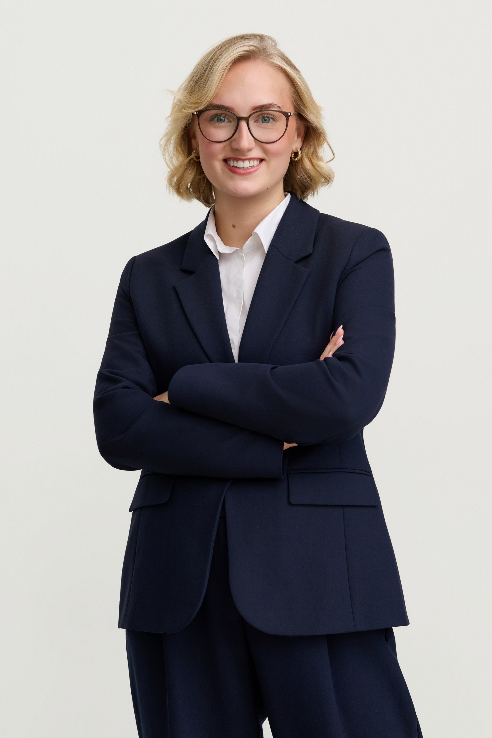 Studio portrait, arms crossed, navy blazer