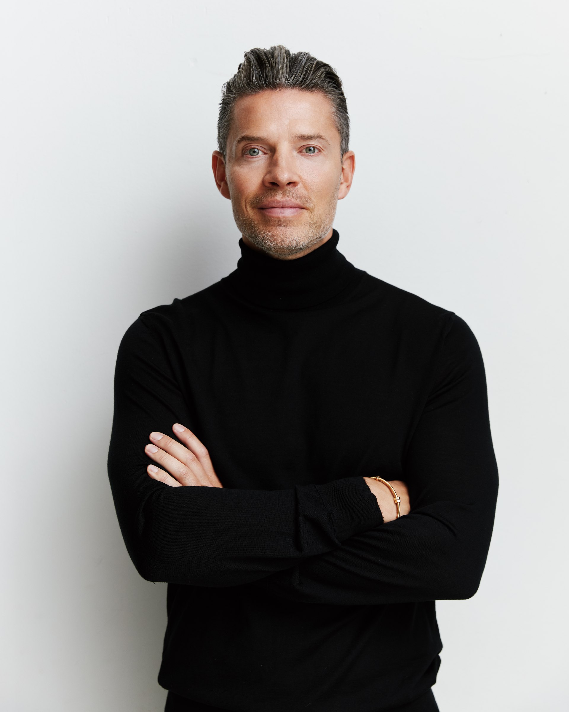 Studio portrait, black turtleneck, arms crossed